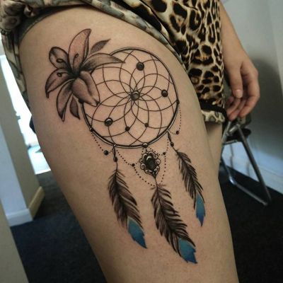 Tatouage attrape rêve avec une fleur et des plumes noires et bleues sur la cuisse